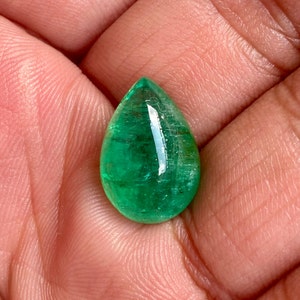 May include: A teardrop-shaped emerald gemstone with a deep green colour and a polished finish.