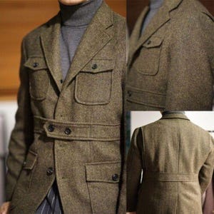 May include: A brown tweed jacket with multiple pockets and a belted waist. The jacket has a classic design with a button closure and a high collar. The fabric has a textured appearance, and the jacket is worn over a gray turtleneck.
