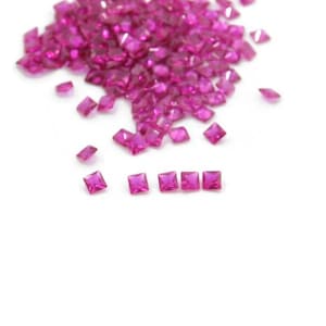 Puede incluir: Un montón de piedras preciosas cuadradas de color rosa, con una fila de siete piedras preciosas alineadas debajo.