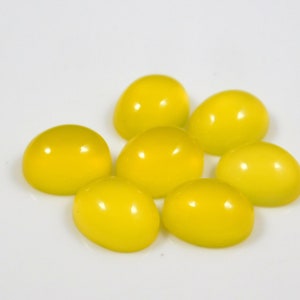 K&ouml;nnte beinhalten: Acht ovale, leuchtend gelbe Edelsteine auf einer wei&szlig;en Oberfl&auml;che.