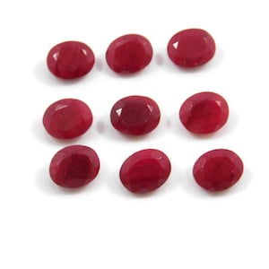 May include: Ten oval-shaped, red gemstones. The gemstones are faceted and have a smooth, polished finish.