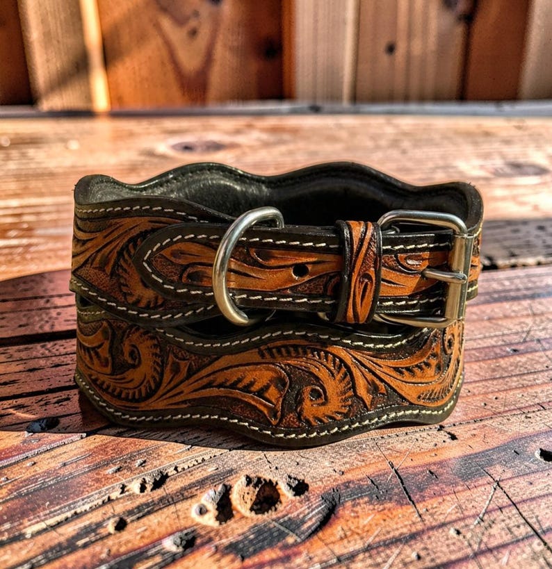 Peut inclure: Un collier de chien en cuir marron et noir avec un outillage floral complexe. Le collier est dot&eacute; d'une boucle et d'un anneau en D argent&eacute;s, et est cousu avec du fil blanc. Le cuir a un bord ondul&eacute;.