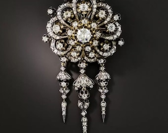 May include: A silver and gold brooch with a large, ornate floral design set with diamonds. The brooch has three dangling chains of diamonds.