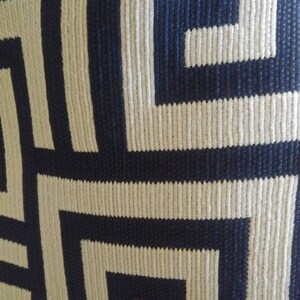 Pu&ograve; includere: Primo piano di un tessuto tessuto con un motivo geometrico blu navy e bianco. Il motivo &egrave; un motivo a chiave greca ripetuto.