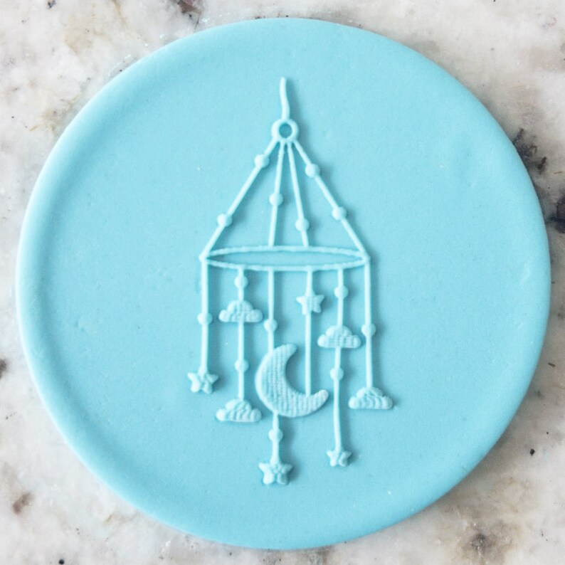 May include: A light blue silicone baby mobile mold with a crescent moon, stars, and clouds design.