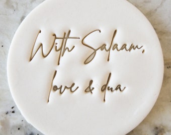May include: White ceramic coaster with the text "With Salaam, love & dua" in gold lettering.
