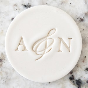 Peut inclure: Tampon rond en céramique blanche avec les lettres A & N et un symbole ampersand décoratif entre les deux.