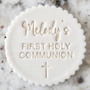 Può includere: Topper per torta rotondo bianco con il testo "Melody's First Holy Communion" e una croce.