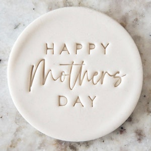 Peut inclure: Tampon rond en céramique blanche avec le texte "Happy Mother's Day" en relief au centre.