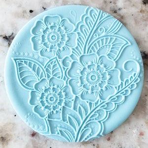 May include: A light blue silicone mould with a floral design. The mould features three large flowers with intricate details and leaves.