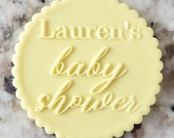 Könnte beinhalten: Ein runder gelber Tortendekor mit dem Text "Lauren's baby shower" in Weiß.