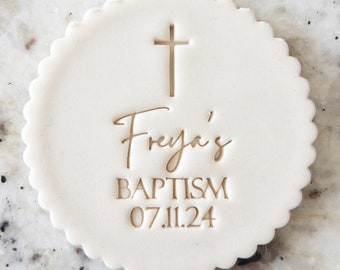 Puede incluir: Galletas redondas blancas con borde festoneado, con una cruz dorada, el texto " Freya's Baptism 07.11.24" en letras doradas.