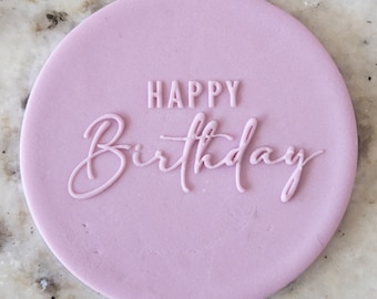 Op de afbeelding: Een ronde, lichtpaarse taarttopper met de tekst "Happy Birthday" in wit.
