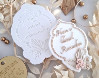 May include: Two white silicone molds for baking, one with the text "Have a blessed Ramadan" and the other with the text "Have a blessed Ramadan" in Arabic. The molds are shaped like a traditional Islamic arch.