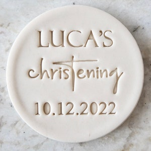 May include: White ceramic round disc with the text "LUCA'S christening 10.12.2022" engraved on it.