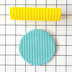 May include: A set of two silicone rolling pins for baking. The larger rolling pin is yellow and has a herringbone pattern. The smaller rolling pin is teal blue and has a herringbone pattern.