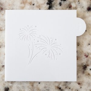 May include: White plastic stencil with a design of two fireworks with stars.
