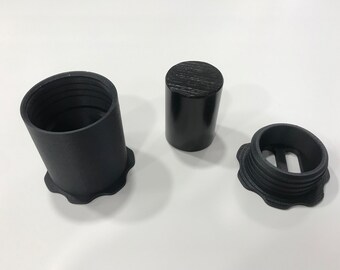Peut inclure: Trois contenants en plastique noir avec une surface texturée. Un contenant est un cylindre avec un couvercle. Les deux autres contenants sont ouverts et ont un bord cranté.