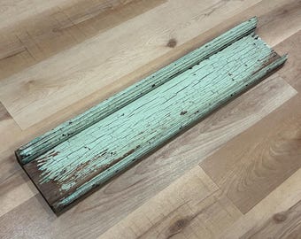 Frontón antiguo recuperado, agrietado y desconchado, pintado de verde