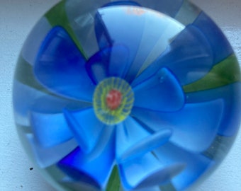 Presse-papiers en verre vintage avec une seule fleur bleu vif avec des étamines jaunes et des feuilles vertes c 1960 Aster Daisy