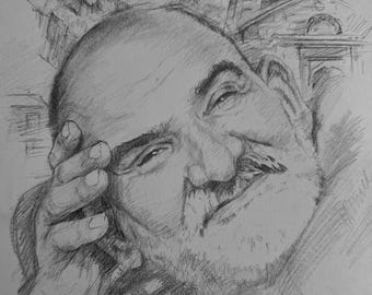 May include: A graphite pencil drawing on paper featuring a portrait of a bald individual with a mustache, resting their head on one hand. In the background, there is a sketch of a mountain landscape and a stone building with a tall tower structure.