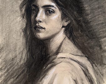 May include: A charcoal and white chalk drawing on toned paper depicting a portrait of a person with long, dark, flowing hair. The subject is shown from the chest up, wearing a simple, light-colored garment with soft, draped folds around the shoulders.