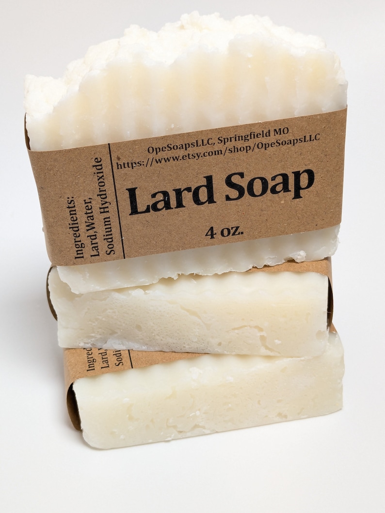 Pu&ograve; includere: Una pila di tre barre rettangolari di sapone allo strutto bianco avvolte in etichette di carta marrone. L'etichetta superiore riporta Lard Soap, 4 oz., OpeSoapsLLC, Springfield MO, ed elenca gli ingredienti Lard, Water, Sodium Hydroxide.