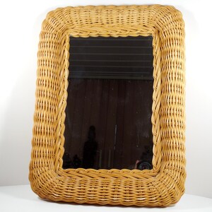 May include: A rectangular wicker mirror with a natural brown finish. The mirror has a simple, classic design and would add a touch of rustic charm to any room.
