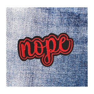 May include: A red and black embroidered patch with the word "nope" in a cursive font. The patch is set against a blue denim background, creating a contrast between the vibrant text and the textured fabric.
