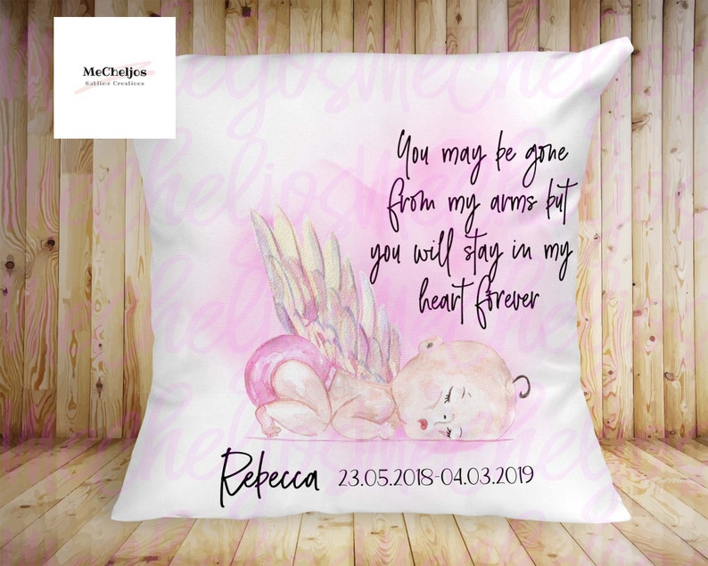 May include: A white pillow with a pink watercolor background and a quote that reads "You may be gone from my arms but you will stay in my heart forever". The pillow also features a watercolor illustration of a baby angel with wings and the name "Rebecca" and the dates "23.05.2018-04.03.2019".