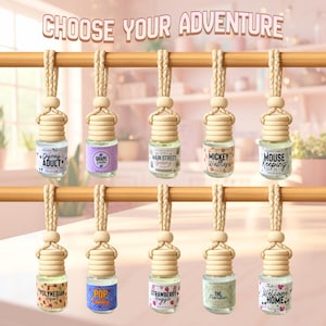 May include: Ten small glass car air freshener bottles with wooden caps and braided rope hangers, arranged in two rows. Each bottle features a unique label with text including Disney Adult, Grape Soda, Main Street Bakery, Mickey Waffles, and Mouse Keeping.
