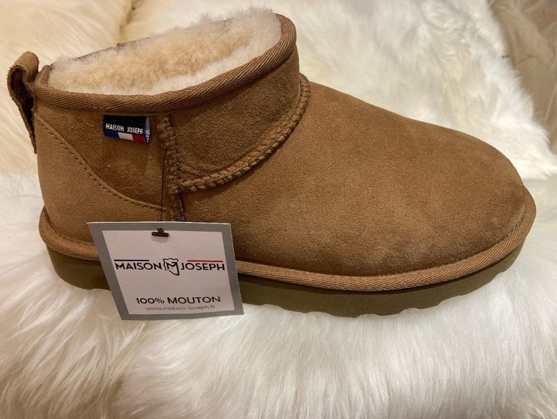 K&ouml;nnte beinhalten: Braune Wildlederstiefel aus Schaffell mit wei&szlig;em Schaffellfutter. Die Stiefel haben ein Etikett mit der Aufschrift "Maison Joseph 100% Mouton".