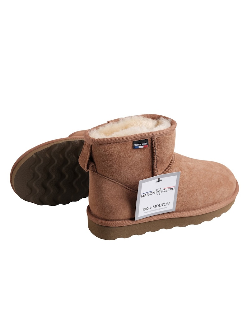 May include: Brown suede shearling boots with a white shearling lining. The boots have a black rubber sole and a tag that says "Maison Joseph 100% Mouton".