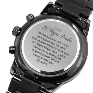 May include: Black chronograph watch with a silver back engraved with the words "Para El Mejor Padre" and a message in Spanish. The message reads: "No hay palabras suficientes para agradecerte por todo. Eres un gran hombre y es un gran privilegio tenerte como padre. Gracias por tu dedicación, tu apoyo y amor infinito, nunca olvides que TE AMO."