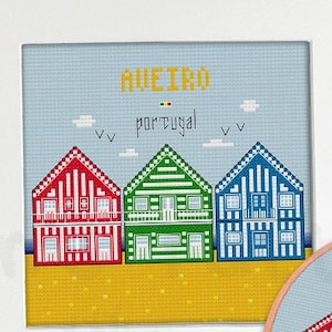 Könnte beinhalten: Kreuzstichmuster mit bunten Strandhäusern in Aveiro, Portugal. Das Muster enthält den Text "Aveiro, Portugal" und ein kleines Bild der portugiesischen Flagge.