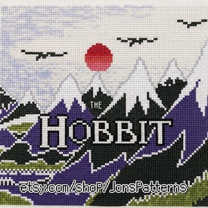 May include: A cross-stitch embroidery featuring a mountain landscape with a red sun and black birds in the sky. The text THE HOBBIT is centered in white letters. The bottom includes the text etsy.com/shop/JonsPatterns in white letters.