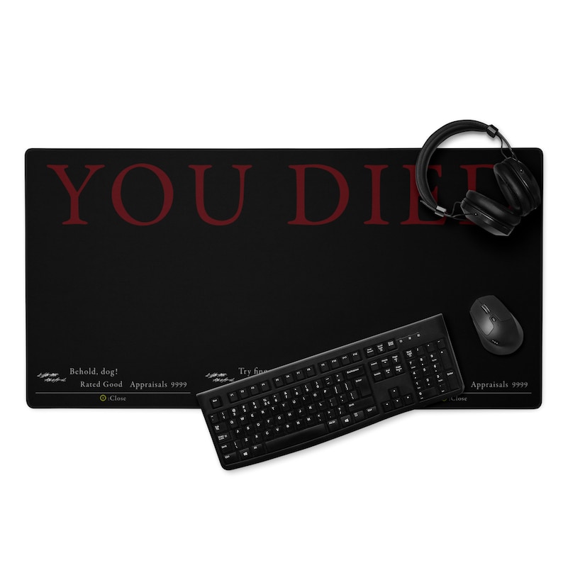 Puede incluir: Alfombrilla de rat&oacute;n para juegos negra con el texto "YOU DIED" en rojo. La alfombrilla de rat&oacute;n se muestra con un teclado negro, un rat&oacute;n negro y unos auriculares negros.