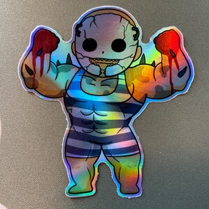 May include: A holographic sticker of a cartoon character with a large, muscular body wearing a blue and white striped swimsuit. The character has a large, white mask with a toothy grin and is flexing both arms.