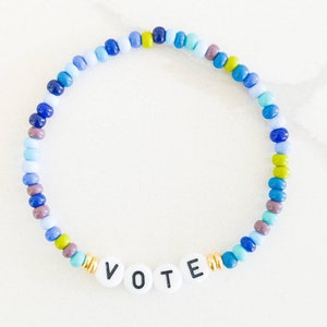 May include: A blue, green, and purple beaded bracelet with the word "VOTE" spelled out in white letters.
