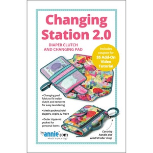 May include: Changing Station 2.0 diaper clutch and changing pad. The image shows a diaper clutch with a colorful floral pattern, a teal handle, and a matching changing pad. Includes a coupon for a video tutorial.