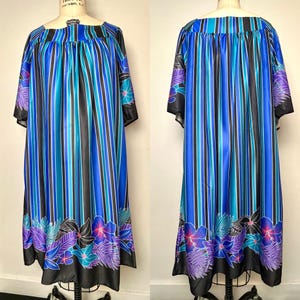 May include: A vintage blue, black, and teal striped dress with floral accents. The dress features a square neckline, short sleeves, and a knee-length hemline. The floral design includes purple, blue, and black flowers and leaves. The dress is displayed on a mannequin.