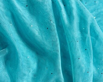May include: Close-up of a turquoise tulle fabric with a delicate, net-like texture. The fabric is gathered in soft folds, and scattered throughout are tiny, sparkling sequins that catch the light, creating a shimmering effect.