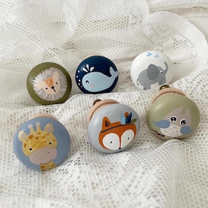 Könnte beinhalten: Sechs Holzgriffe mit bemalten Tiermotiven. Die Griffe zeigen einen blauen Wal, einen grünen Löwen, eine blaue Giraffe, einen blauen Fuchs, einen grauen Elefanten und eine grüne Eule.