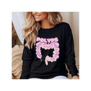 May include: Black sweatshirt with a pink and purple graphic of a colon with the text "POLYPS I MUST FIND YOU THERE" around it.