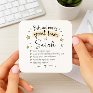 May include: A square white coaster with rounded corners featuring black text that reads: Behind every great team is Sarah. It includes a list of five bullet points with checkmarks, yellow star accents, and a small heart at the bottom.