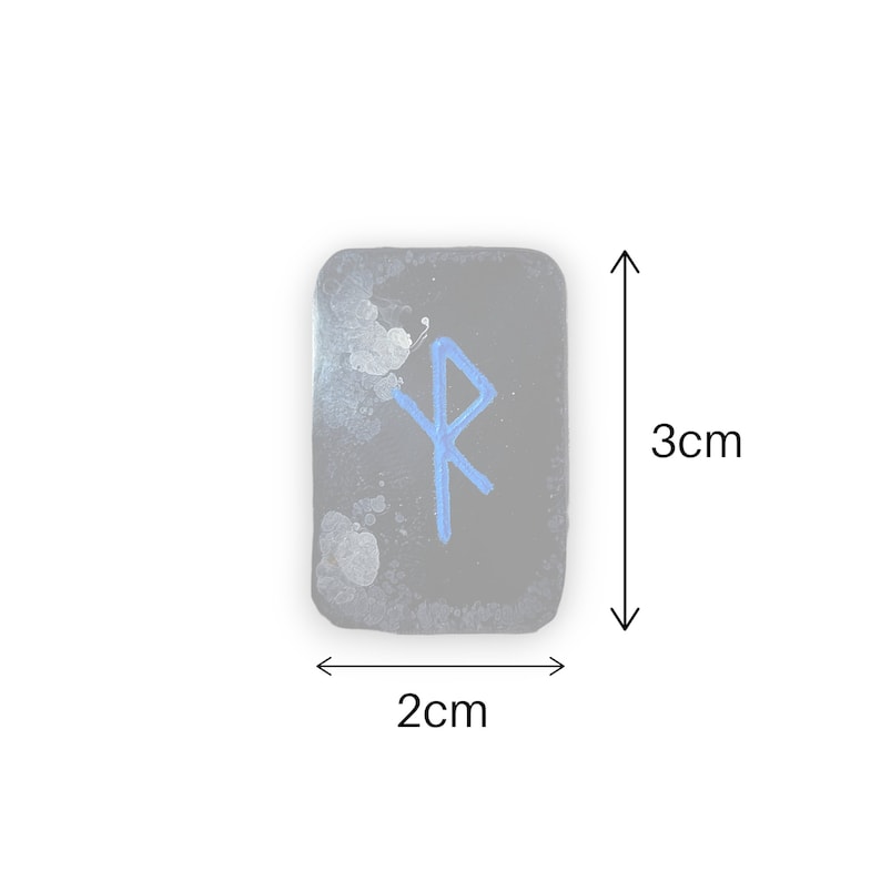 May include: A small, black, rectangular stone with a blue rune symbol painted on it. The stone measures 2 inches by 3 inches.