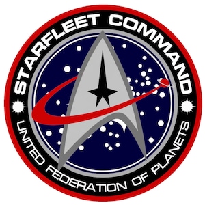 Puede incluir: Un emblema circular rojo, blanco y negro con el texto "Starfleet Command United Federation of Planets" alrededor del borde. El centro del emblema presenta una nave espacial plateada con un arco rojo y una estrella en el centro, sobre un fondo azul oscuro con puntos blancos.