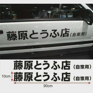 Könnte beinhalten: Ein weißer Auto-Tür-Aufkleber mit schwarzem japanischen Text, der 藤原とうふ店 (自家用) lautet. Der Aufkleber misst 10 cm in der Höhe und 90 cm in der Breite. Das Design ist auf einer weißen Fahrzeugtür und als Grafik auf weißem Hintergrund zu sehen.