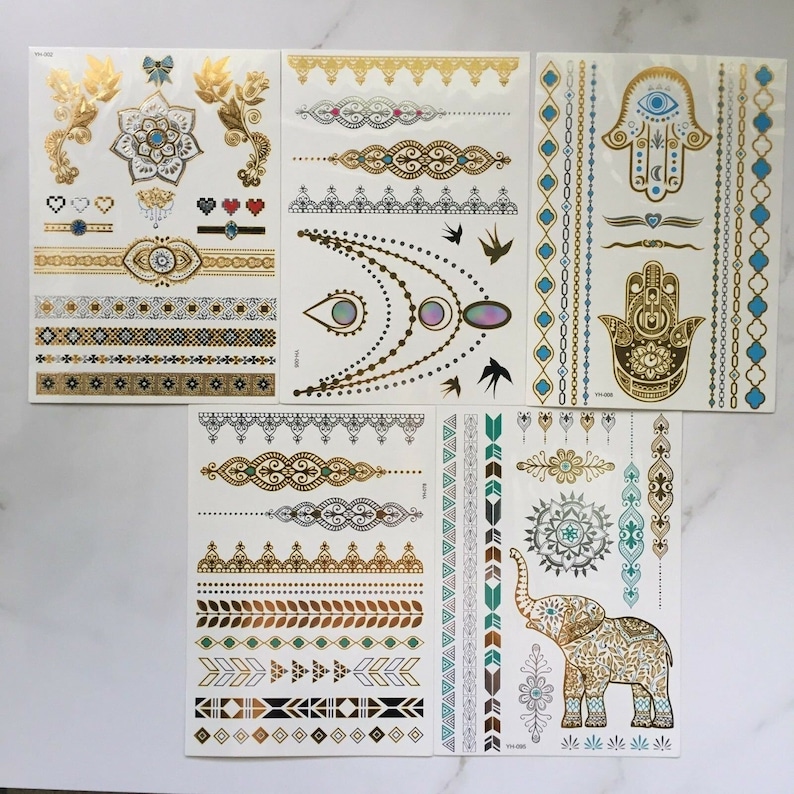 May include: Set of gold and turquoise temporary tattoos with various designs including a hamsa hand, an elephant, and geometric patterns.