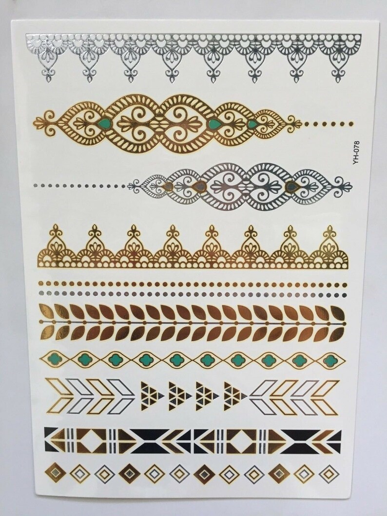 May include: A sheet of temporary tattoos with a variety of gold, silver, and black designs. The designs include geometric patterns, floral motifs, and arrows. The sheet is labeled "YH-078".
